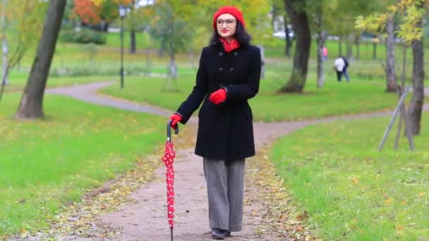 Женщина танцует в осеннем парке с зонтиком — стоковое видео