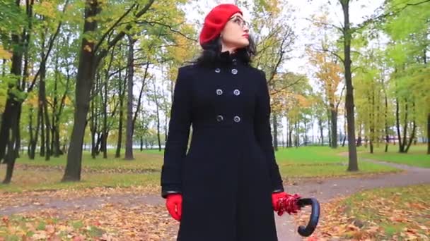 Woman with red umbrella looking for something. — Stock Video