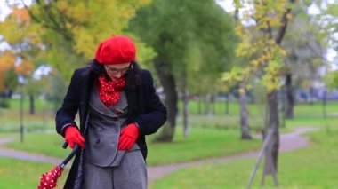 bir kadın sonbahar parkında ceketinin düğmelerini çözer