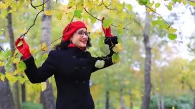 Sonbahar parkında dans eden ve şarkı söyleyen kadın. öğretmenler günü