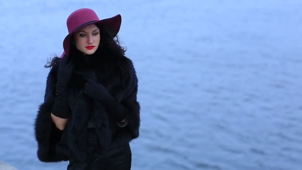 Úžasná žena v červeném klobouku na pozadí vody — Stock video