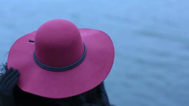 Amazing woman in a red hat on the background of water. Close up — Stock Video