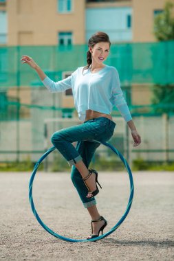 Bir spor çember üzerinde kot ince bir bel ile Şık kız