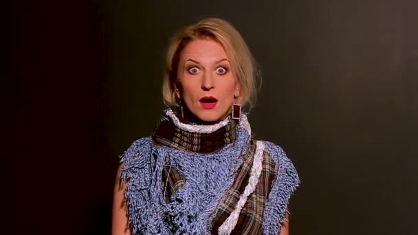 Medium close-up of young woman, isolated on a black background, looking at the camera and moves her eyebrows — Stock Video