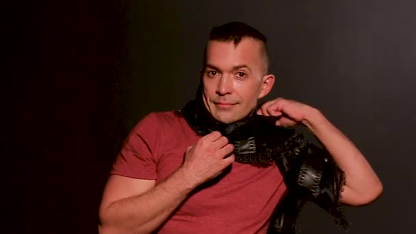 Medium close-up of man, isolated on a black background with scarf, looking at the camera and expressing emotions — Stock Video