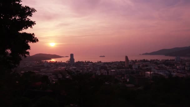 Uitzicht op Patong City, huizen en hotels, nacht lichten, zee en hemel tijdens zonsondergang — Stockvideo