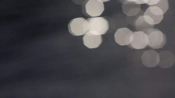 Füstös és fehér bokeh Sun vakító fény tükröződik a víz felszínén. villódzó vízben absztrakt elmosódott ki a hangsúly bokeh háttér — Stock videók
