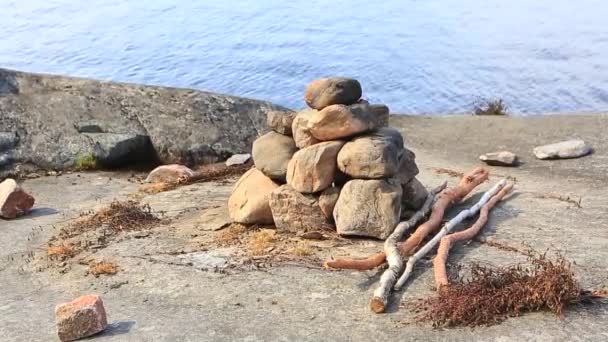 Stenar och brasved för ett hemlagat bad på sjön. — Stockvideo