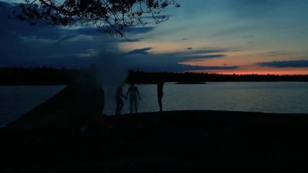 Människor krypa ur en provisorisk badhus och och dansa vid sjön — Stockvideo