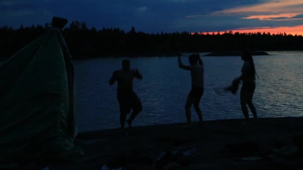 La gente sale de una casa de baños improvisada y bailan junto al lago — Vídeo de stock