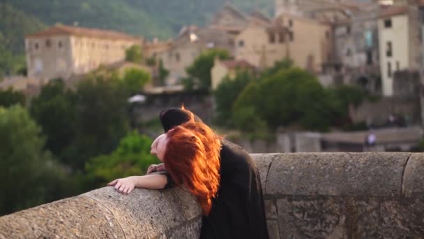 Charming woman in evening black dress, she shows off her beautiful red hair which glows in the rays of the setting sun and leaves the frame — Stock Video