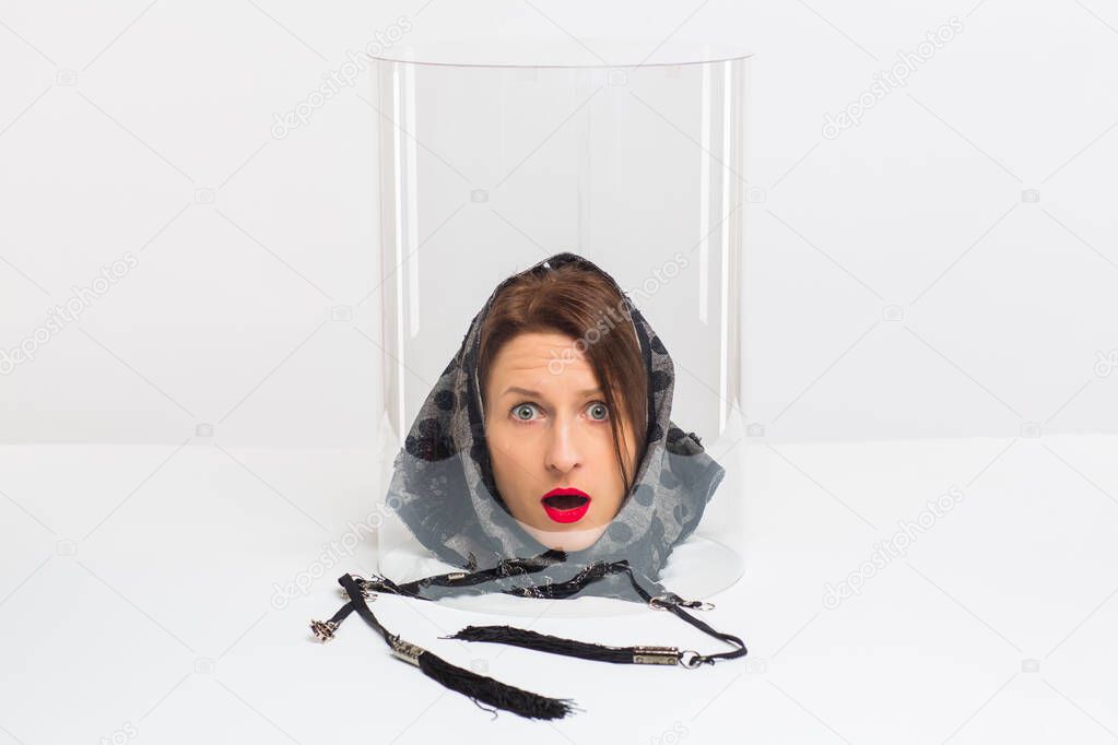 The head of a woman in a scarf under a transparent cap. Conceptually. Emotions, mood, character