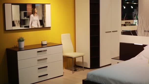 The girl chooses the furniture in a large furniture store. Interior, wardrobe, mirror — Stock Video