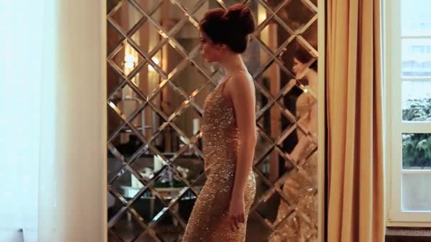 krásná dívka ve večerních šatech snění v místnosti zdobené velkým zrcadlem