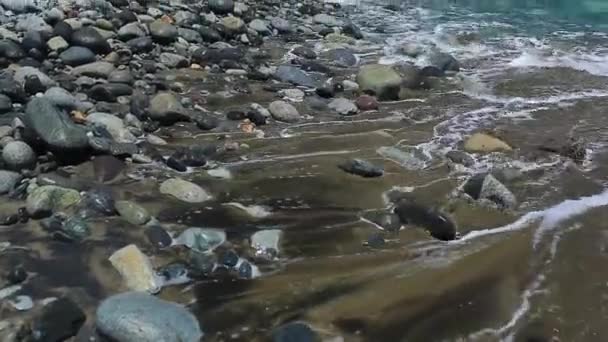 Bølgene kryper opp til de grå steinene og slikker dem. beroligende meditasjonsvideo – stockvideo