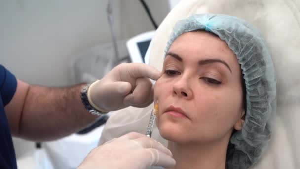 A doctor in white gloves shows what it looks like if the needle is inserted dee under the muscle and if the needle is only under the skin — Stockvideo