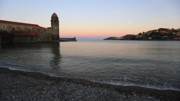 Oktober 2018, Collioure, Frankreich. Sonnenuntergang in der Bucht mit Blick auf den Turm und den aufgehenden Mond — Stockvideo