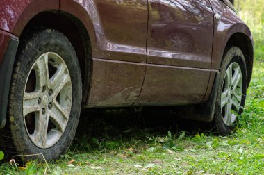 Çimlerin üzerinde kirli tekerlekleri olan SUV