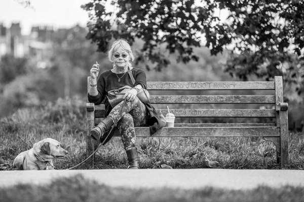 Женщина Сидящая Скамейке Парке Своей Собакой Выставке Собак Курение — стоковое фото