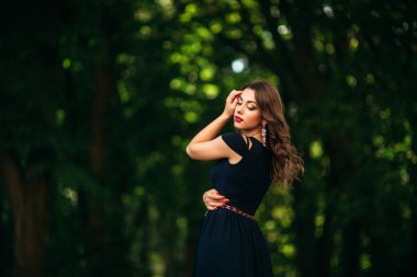 Mavi elbiseli güzel bir kız parkta yürüyor. Güneşli bir gün. Yaz