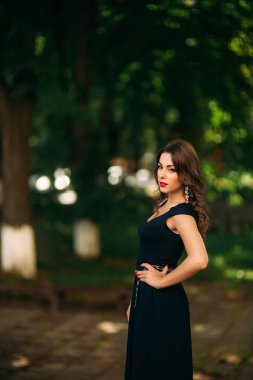 Mavi elbiseli güzel bir kız parkta yürüyor. Güneşli bir gün. Yaz