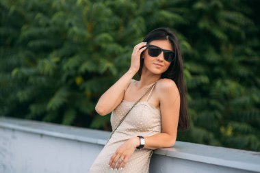 Fotoğrafçılara poz bej renk elbiseli esmer kız