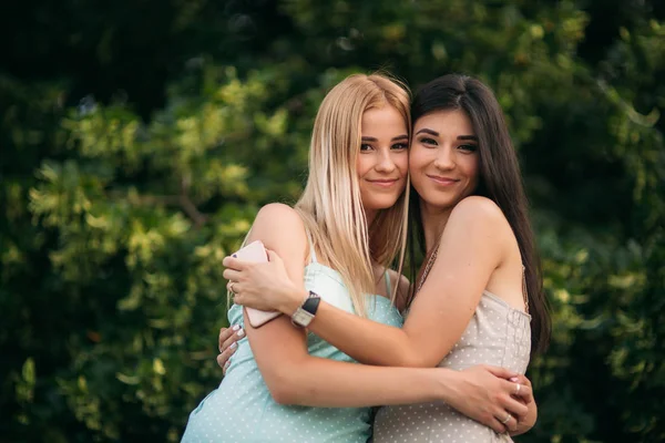 Brunette og blonde er fotograferet og nyder livet. Solrig dag. Sommer - Stock-foto