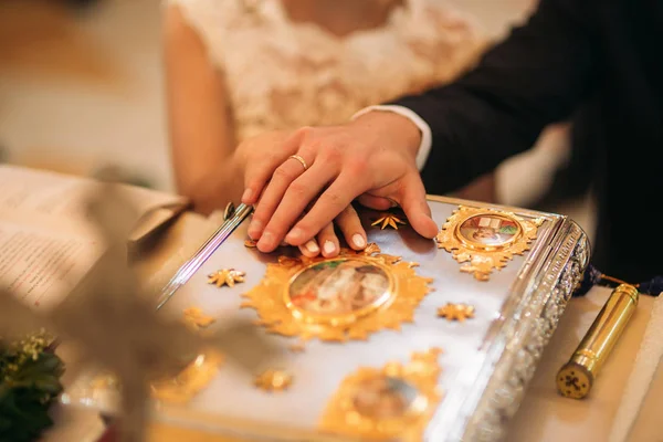 Жених и невеста положили руки на библию — стоковое фото