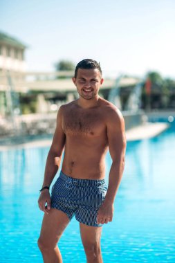 Yüzme havuzundaki yakışıklı adam.