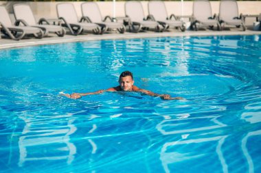 Genç adam Resort'ta yüzme havuzunda atlama