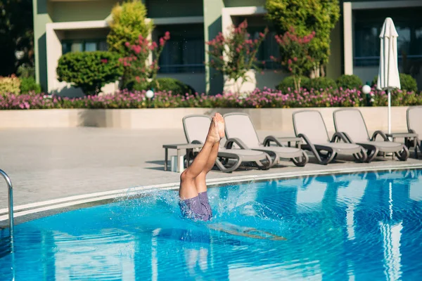 Νεαρός άνδρας άλματα στην πισίνα στο resort — Φωτογραφία Αρχείου