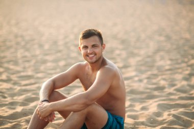 Tropikal bir plajda çekici bir genç adam portresi