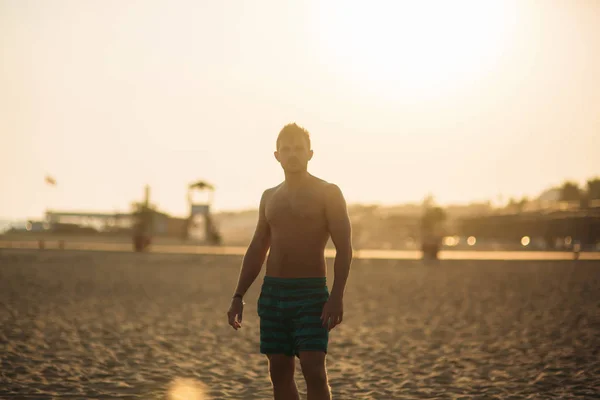 Silueta de hombre guapo en la playa. puesta de sol — Foto de Stock