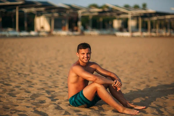 El hombre se sienta en la playa de arena — Foto de Stock