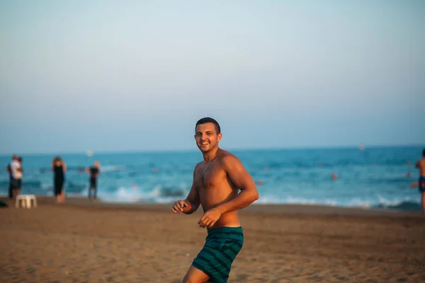Hombre corriendo en la playa al atardecer — Foto de Stock