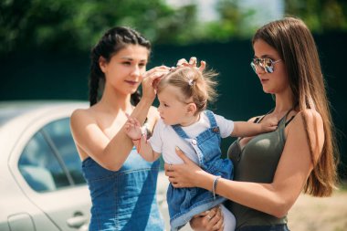 Üç kız kardeş parkta. Kızlar için photosession hazırlanması ve onların saç stilleri ayarlama