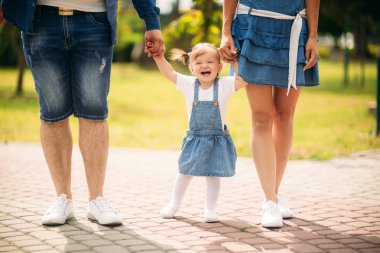 Mutlu neşeli genç Aile Baba, anne ve açık havada eğleniyor, araya yaz park, kırsal oynayan küçük kızı. Anne, baba ve çocuk gülüyor ve sarılma, doğa dışarıda zevk