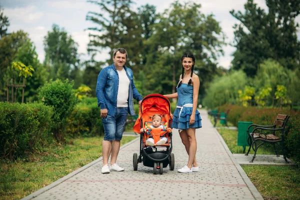 Mama și tata merg în pakr cu un copil în baby buggy — Fotografie, imagine de stoc