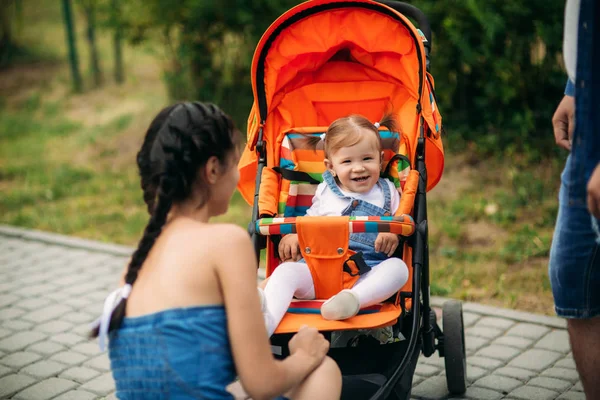 Mama și tata merg în pakr cu un copil în baby buggy — Fotografie, imagine de stoc