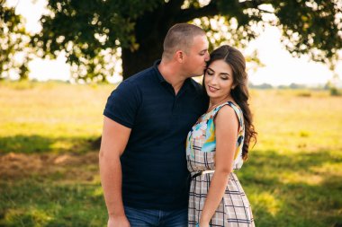 Yakışıklı ve çekici bir kız birbirlerine büyük bir yeşil ağaç sarıl. Aşk hikayesi