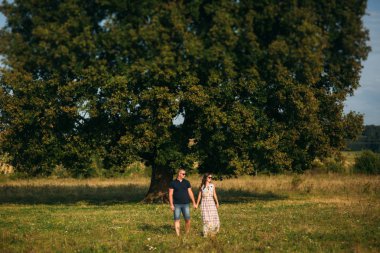 Yakışıklı ve çekici bir kız birbirlerine büyük bir yeşil ağaç sarıl. Aşk hikayesi