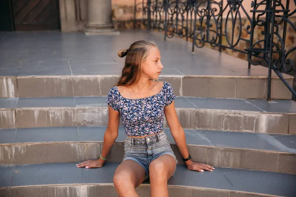 Tiener vrouw gekleed in jeans zit op trap — Stockfoto