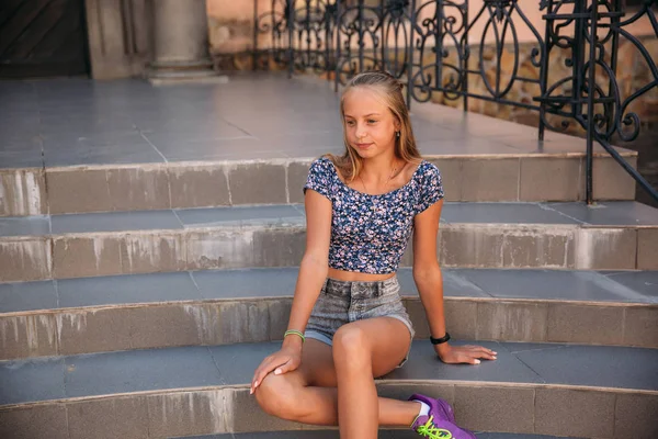 Підліткова жінка одягнена в джинси сидить на сходах — стокове фото