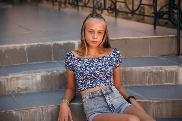 Tiener vrouw gekleed in jeans zit op trap — Stockfoto