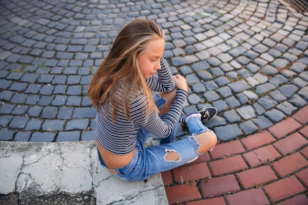 Giovane adolescente posa al fotografo. ragazza bionda in jeans e camicetta — Foto Stock