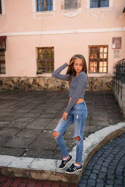 Joven adolescente plantea a fotógrafo. chica rubia en jeans y blusa —  Fotos de Stock