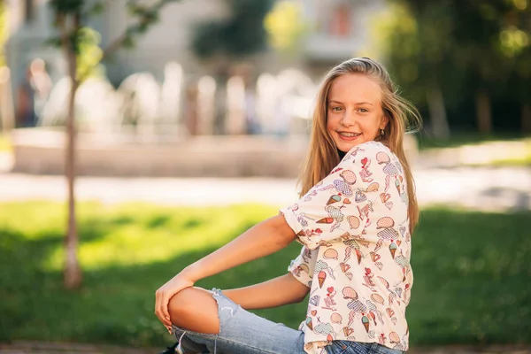 Ung tonårsflicka sitter på bänken — Stockfoto