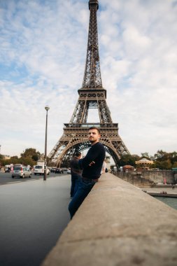 Eiffel Tower bridge arka plan üzerinde duran karanlık kazak içinde yakışıklı adam