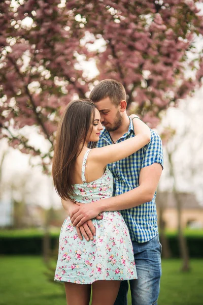 Junges verliebtes Paar beim Ausruhen im blühenden Garten. weiße blühende Bäume — Stockfoto