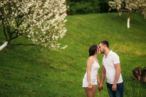 Rande v parku. Láska pár stojící společně na trávníku hned vedle jezera. Romantika a láska — Stock fotografie